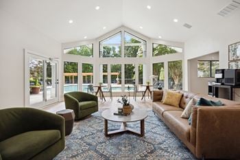 A living room with a vaulted ceiling and large windows